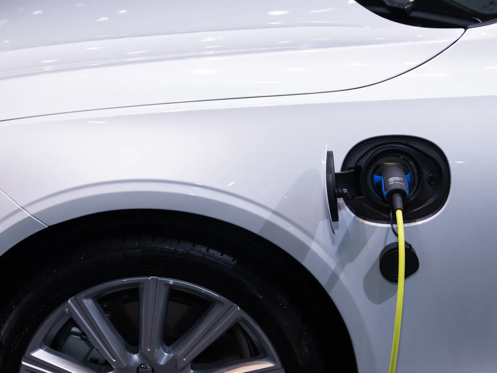 Véhicule électrique blanc branché à un câble de recharge