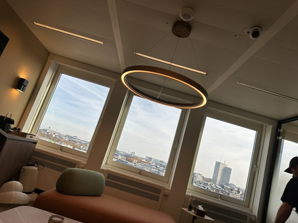 Installation d’une suspension LED circulaire et de luminaires intégrés au plafond réalisée par CharlElec en Belgique